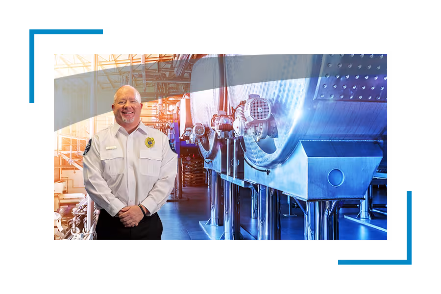 Petrochemical security services, chemical facility security: Smiling Allied universal security professional near industrial equipment