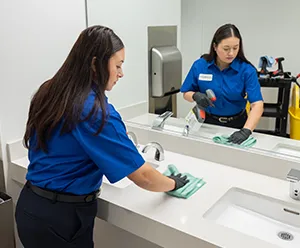 woman cleaning bathroom counter, janitorial services