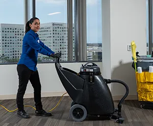 woman using industrial vacuum cleaner, janitorial services