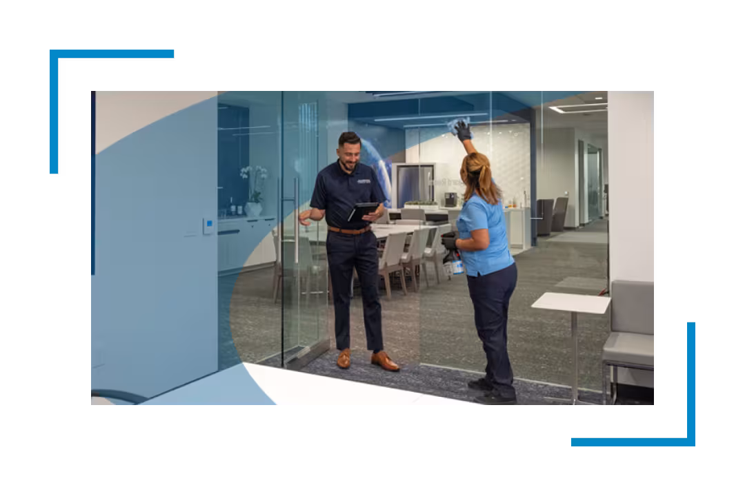 man and woman cleaning glass door in bank