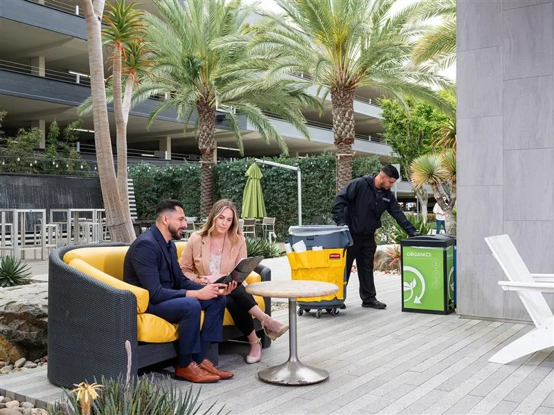 Janitorial Experts cleaning an area while people are working.