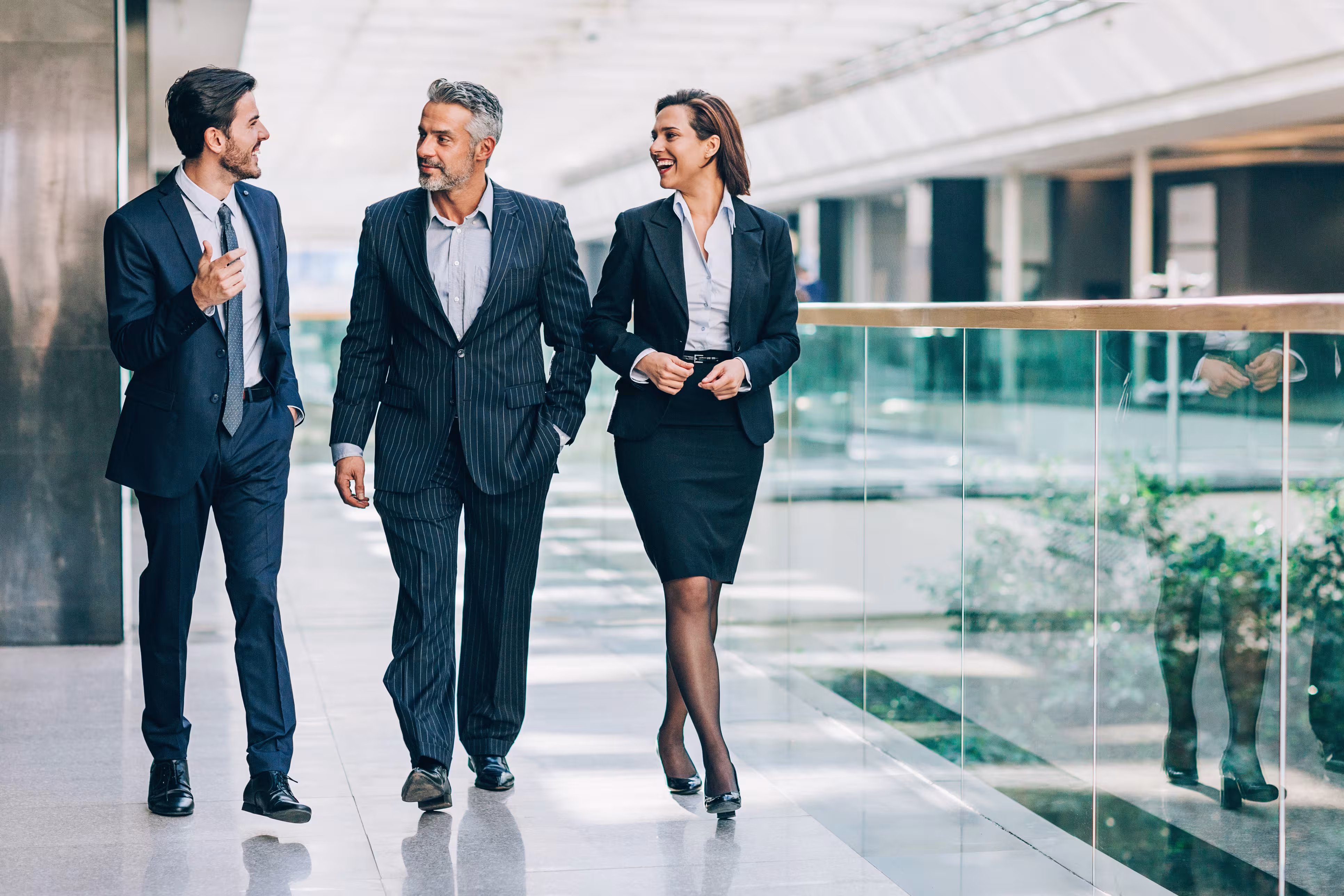 three people walking in formal suite