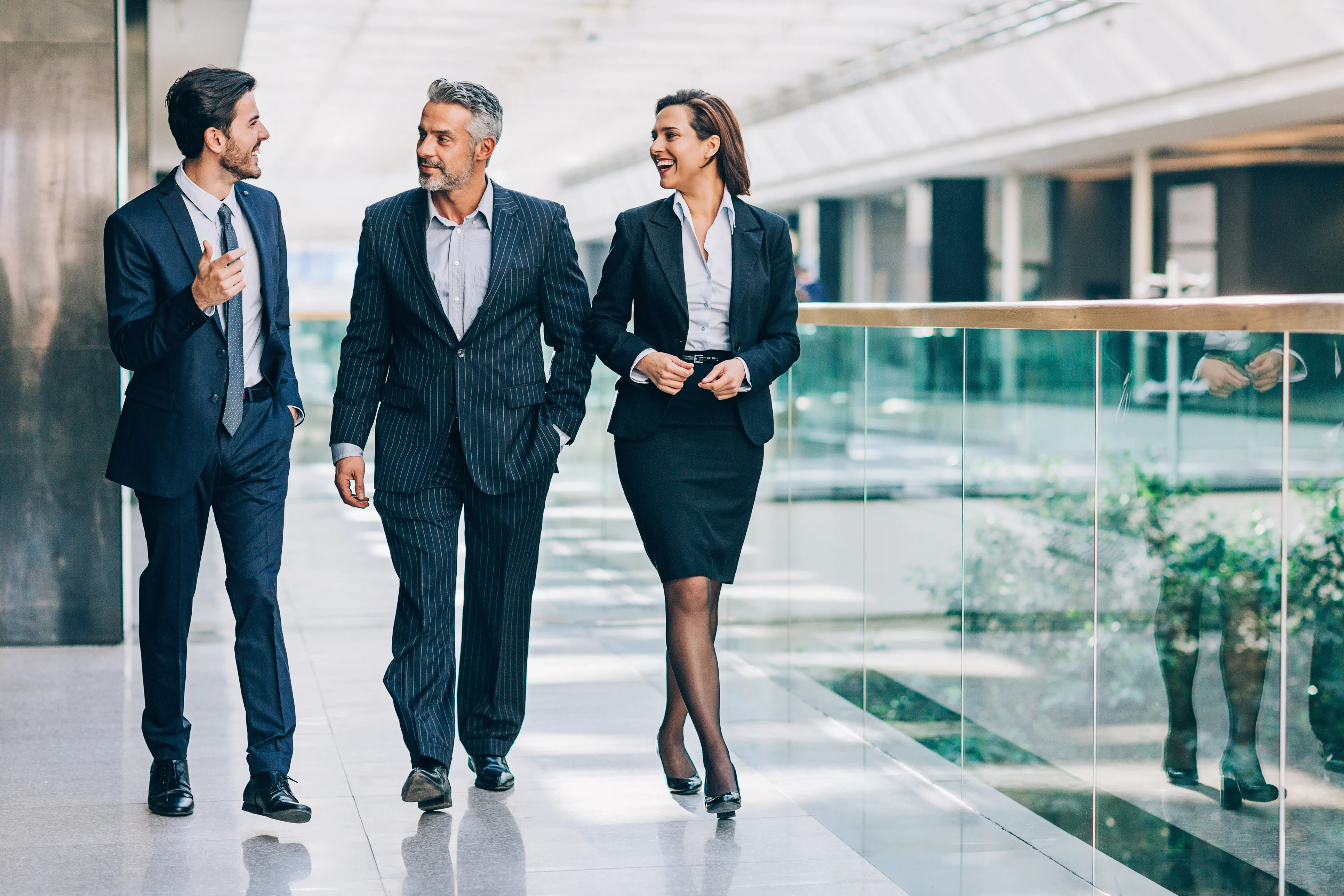 three people walking in formal suite